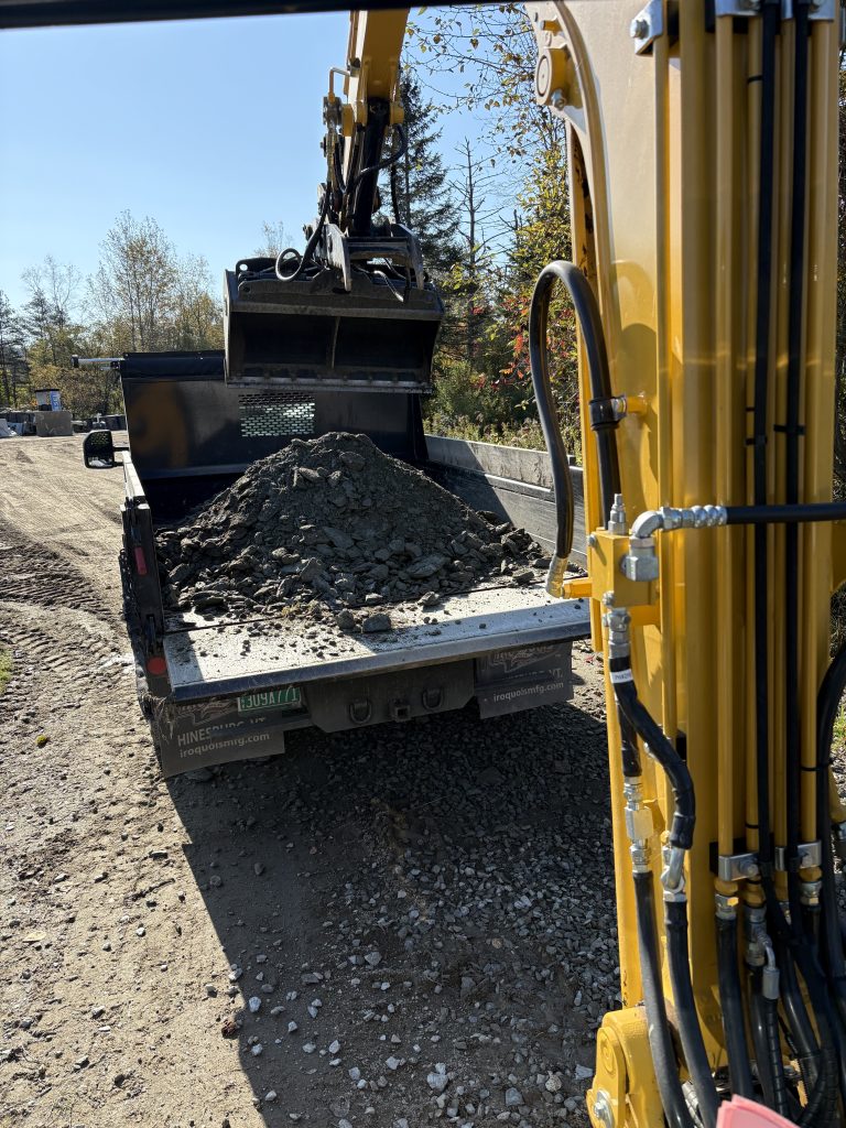 excavator dumping soil on truck bed